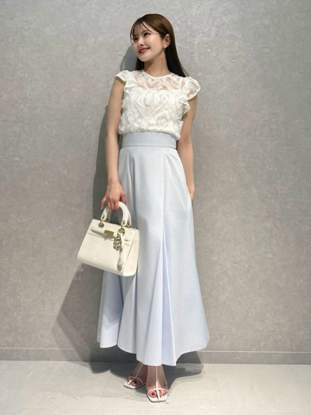 ホワイト系のTシャツ/カットソー、ブルー系のスカート、ホワイト系のサンダルを着用したレディースの夏コーディネートの1枚目の写真