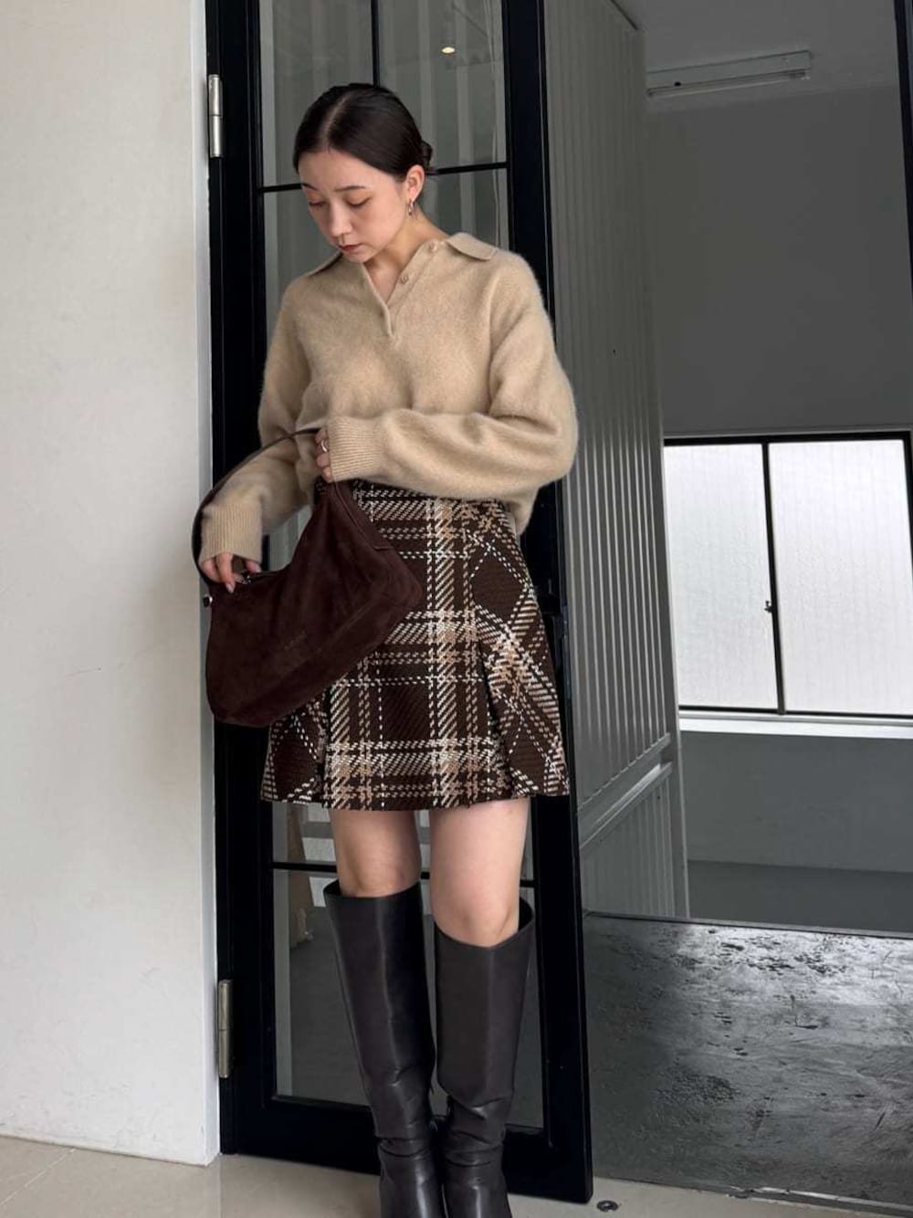 ベージュ系のニット/セーター、ブラウン系のスカートを着用したレディースの秋コーディネートの1枚目の写真