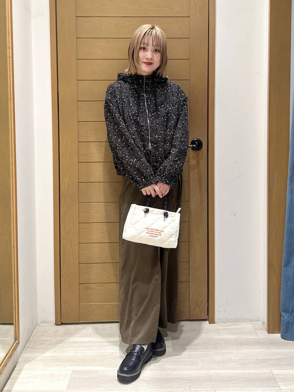 ブラック系のローファー、ブラック系のブルゾン、ホワイト系のショルダーバッグを着用したレディースの春コーディネートの1枚目の写真