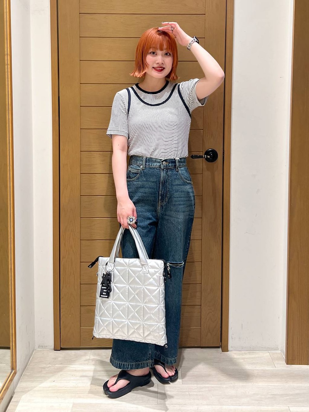 ブラック系のサンダル、ホワイト系のTシャツ/カットソー、シルバー系のトートバッグを着用したレディースの夏コーディネートの1枚目の写真