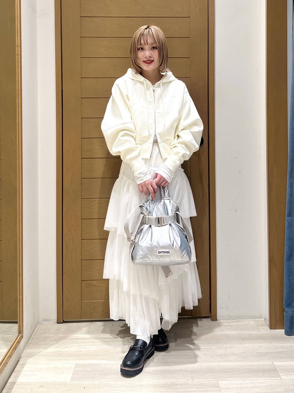 シルバー系のトートバッグ、ブラック系のローファー、ホワイト系のTシャツ/カットソーを着用したレディースの春コーディネートの1枚目の写真