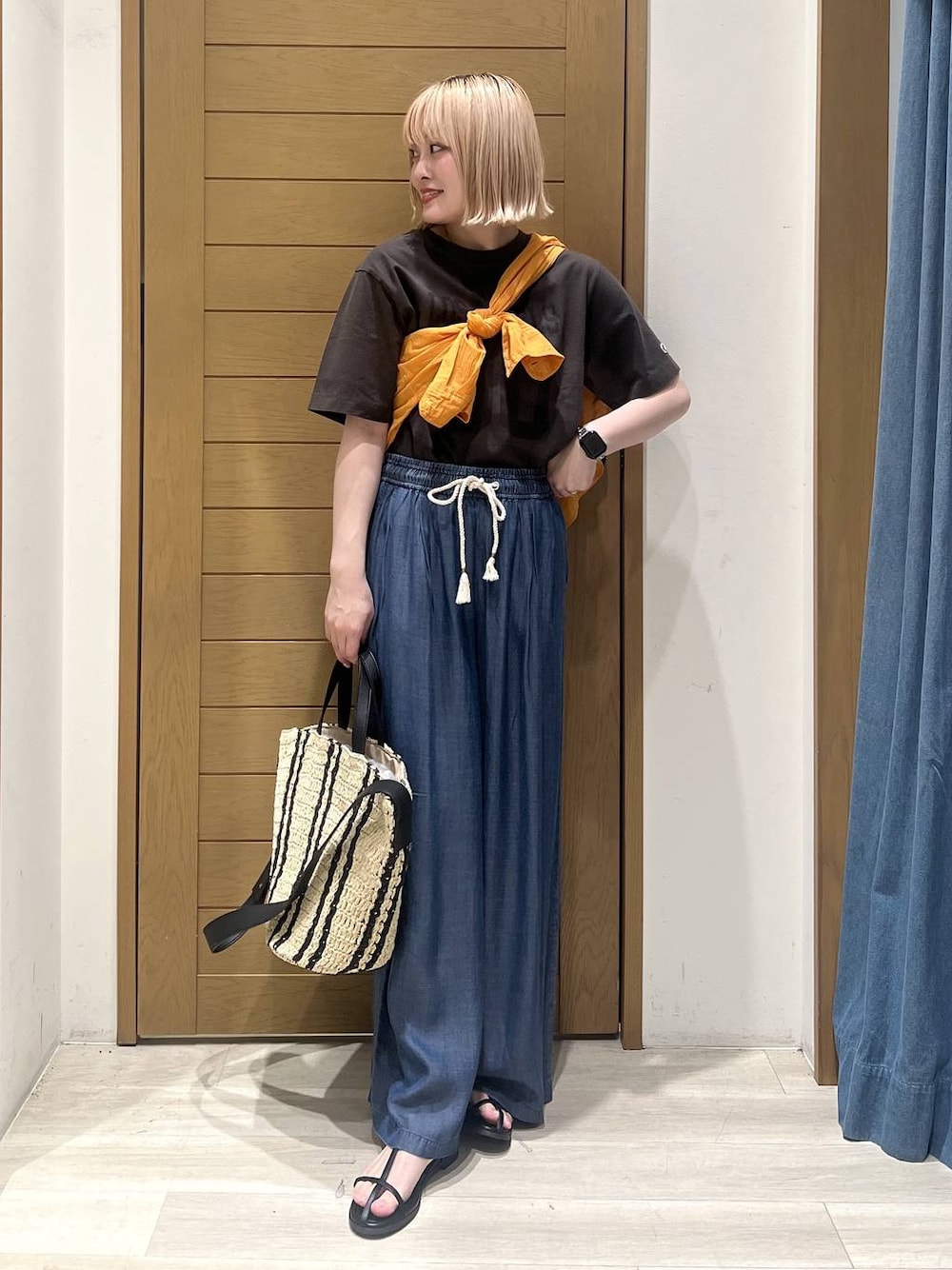 ブラック系のTシャツ/カットソー、オレンジ系のシャツ/ブラウス、ブルー系のデニムパンツを着用したレディースの春コーディネートの1枚目の写真
