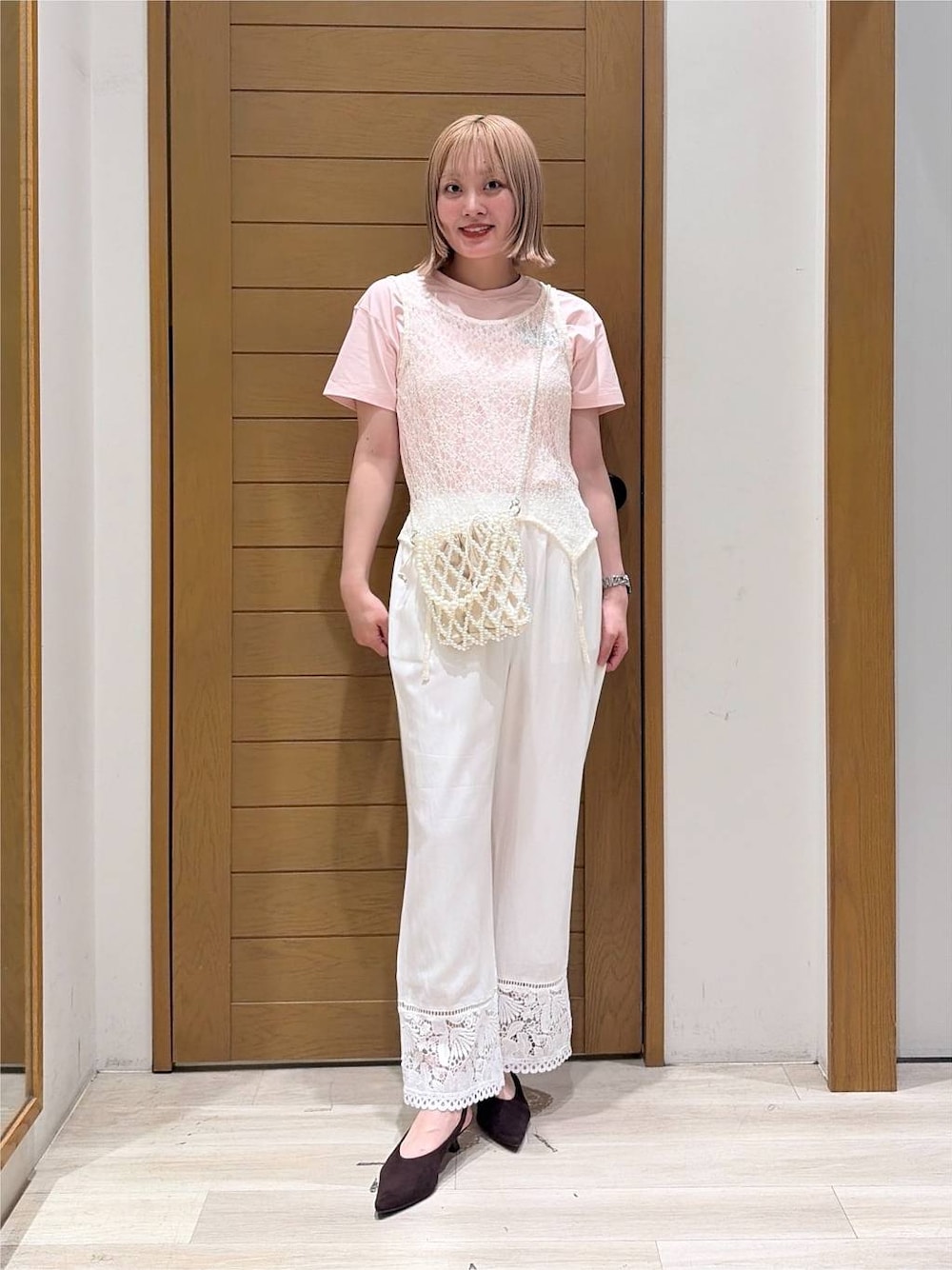 その他のショルダーバッグ、ブラウン系のパンプス、ホワイト系のタンクトップを着用したレディースの夏コーディネートの1枚目の写真