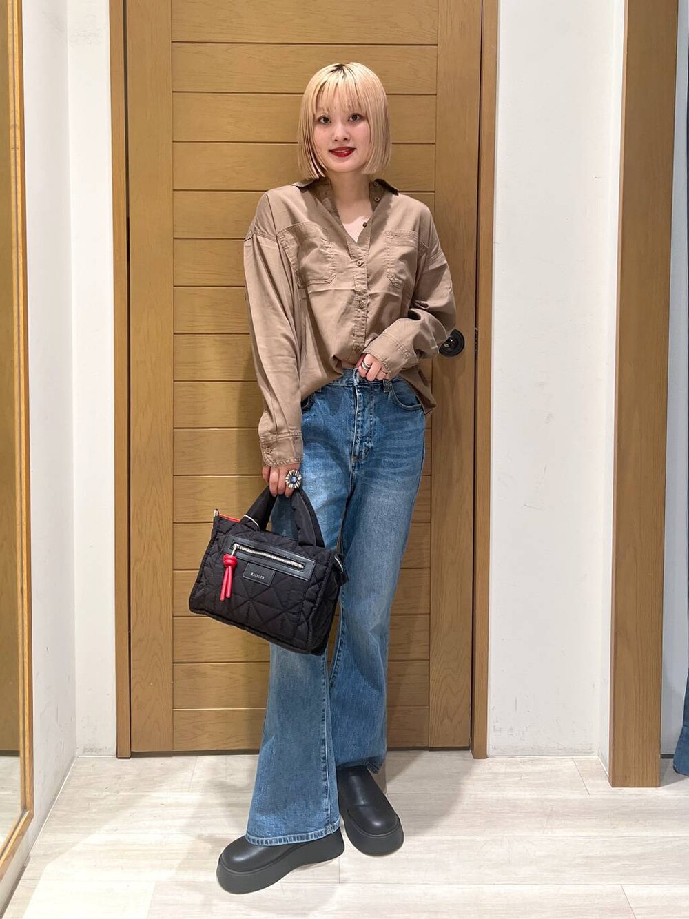 ブラック系のショルダーバッグ、ブラウン系のシャツ/ブラウス、ブルー系のデニムパンツを着用したレディースの夏コーディネートの1枚目の写真