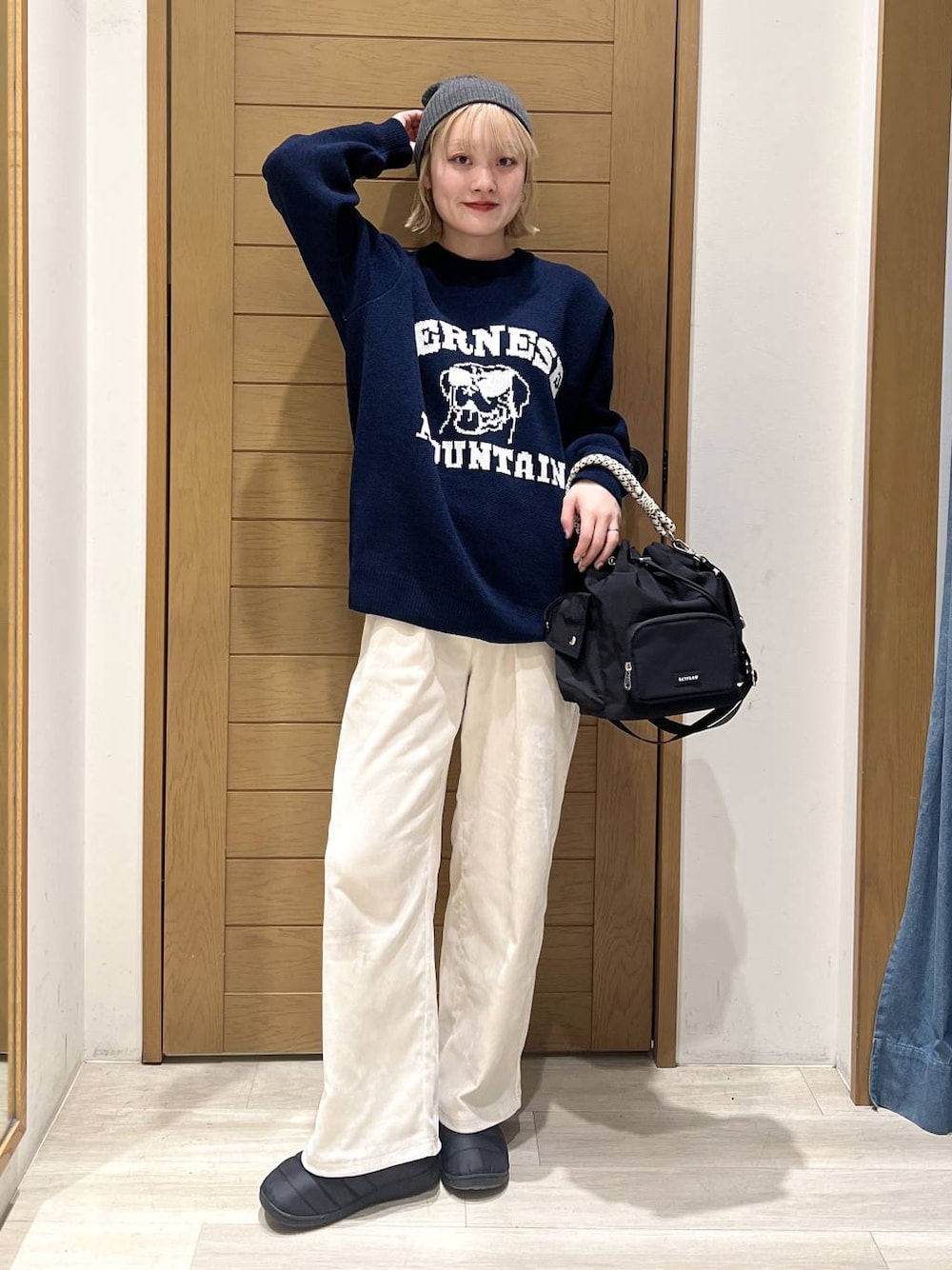 ブラック系のハンドバッグ、ホワイト系のその他パンツ、ブルー系のニット/セーターを着用したレディースの冬コーディネートの1枚目の写真