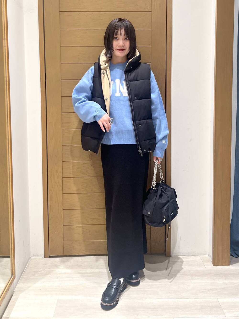 ブルー系のニット/セーター、ブラック系のローファー、ブラック系のハンドバッグを着用したレディースの秋コーディネートの1枚目の写真
