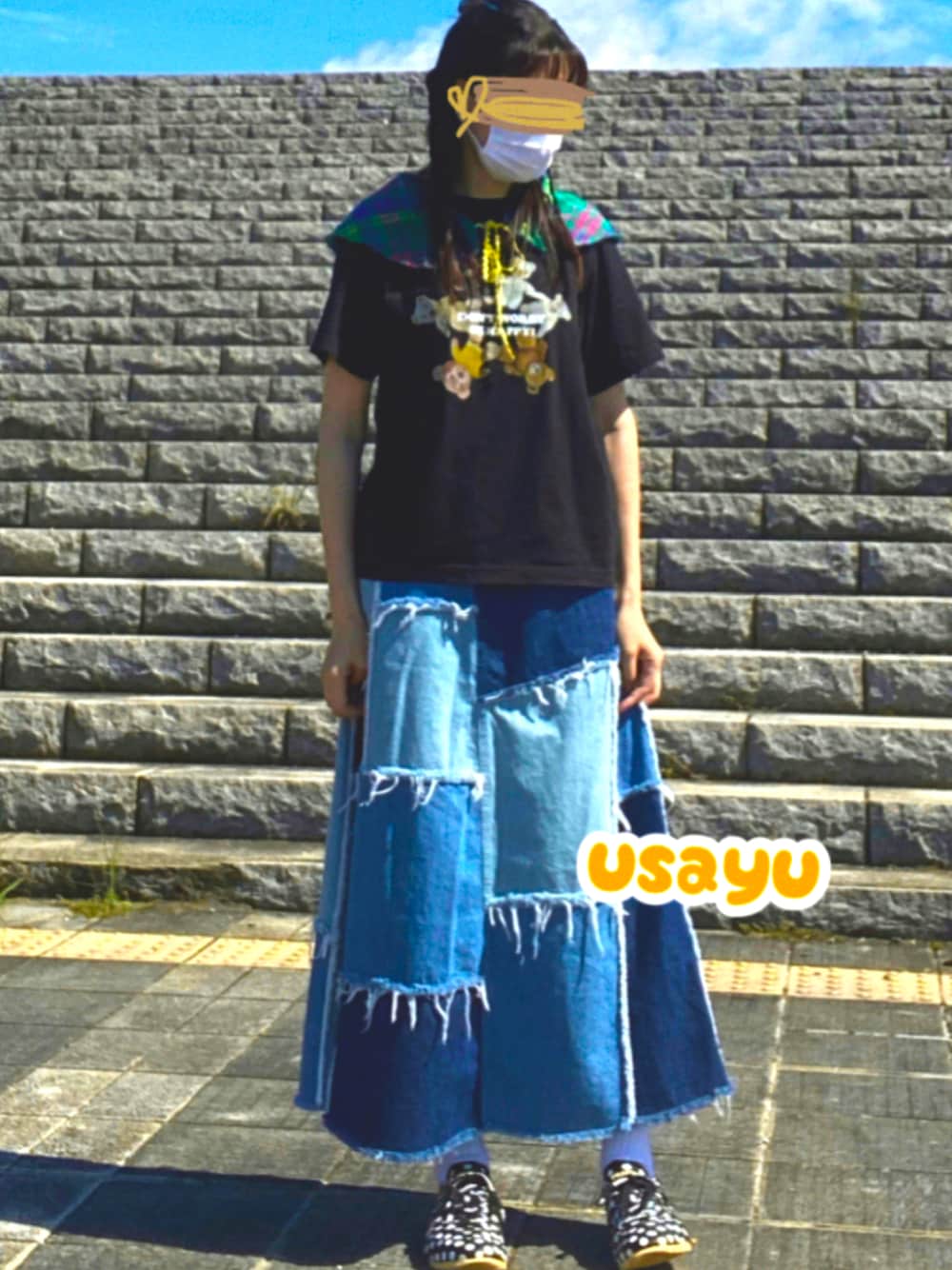 ブラック系のTシャツ/カットソー、ブルー系のデニムスカート、ブラック系のスニーカーを着用したレディースの秋コーディネートの1枚目の写真