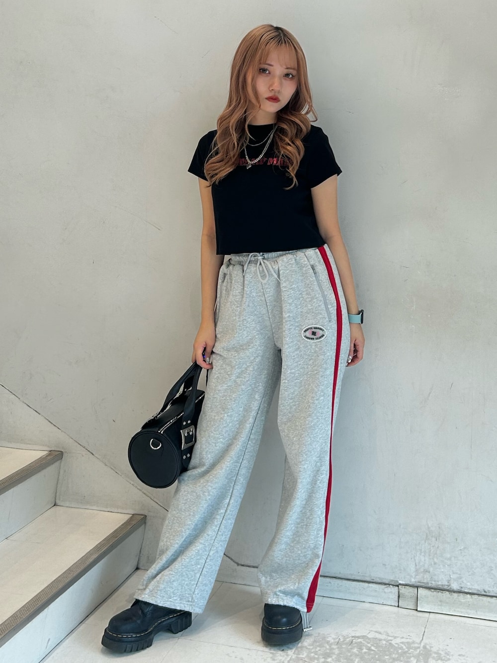 ブラック系のTシャツ/カットソー、グレー系のスウェットパンツ、ブラック系のボストンバッグを着用したレディースの春コーディネートの1枚目の写真