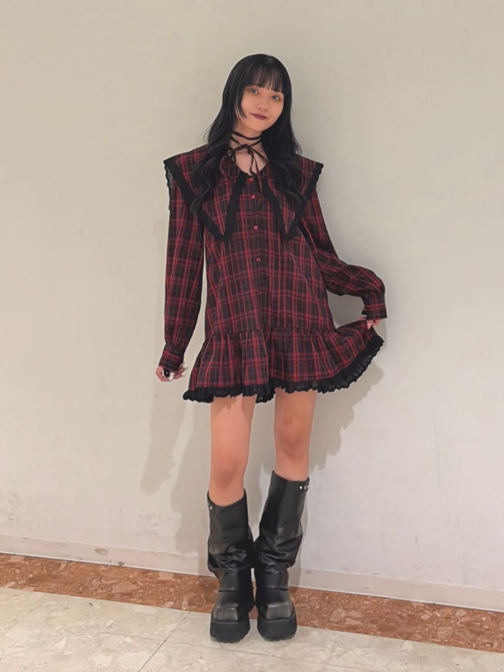 レッド系のワンピース、ブラック系のブーツを着用したレディースの夏コーディネートの1枚目の写真