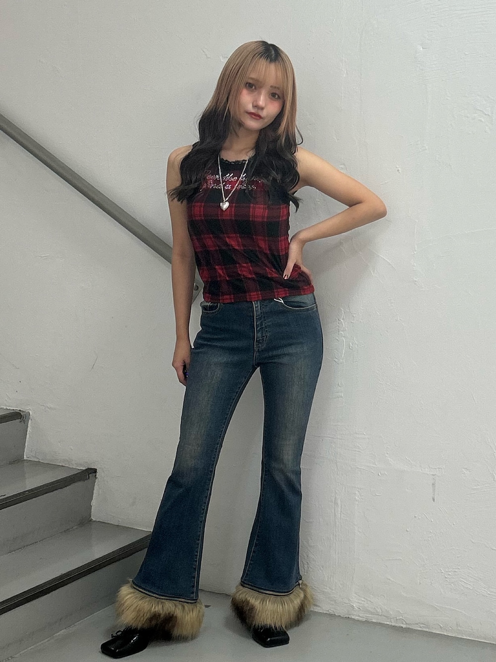 レッド系のタンクトップ、ブルー系のデニムパンツ、シルバー系のネックレスを着用したレディースの夏コーディネートの1枚目の写真