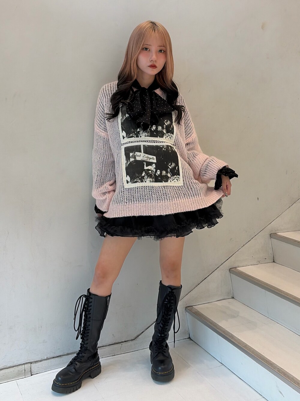 ピンク系のニット/セーター、ブラック系のスカート、ブラック系のシャツ/ブラウスを着用したレディースの秋コーディネートの1枚目の写真