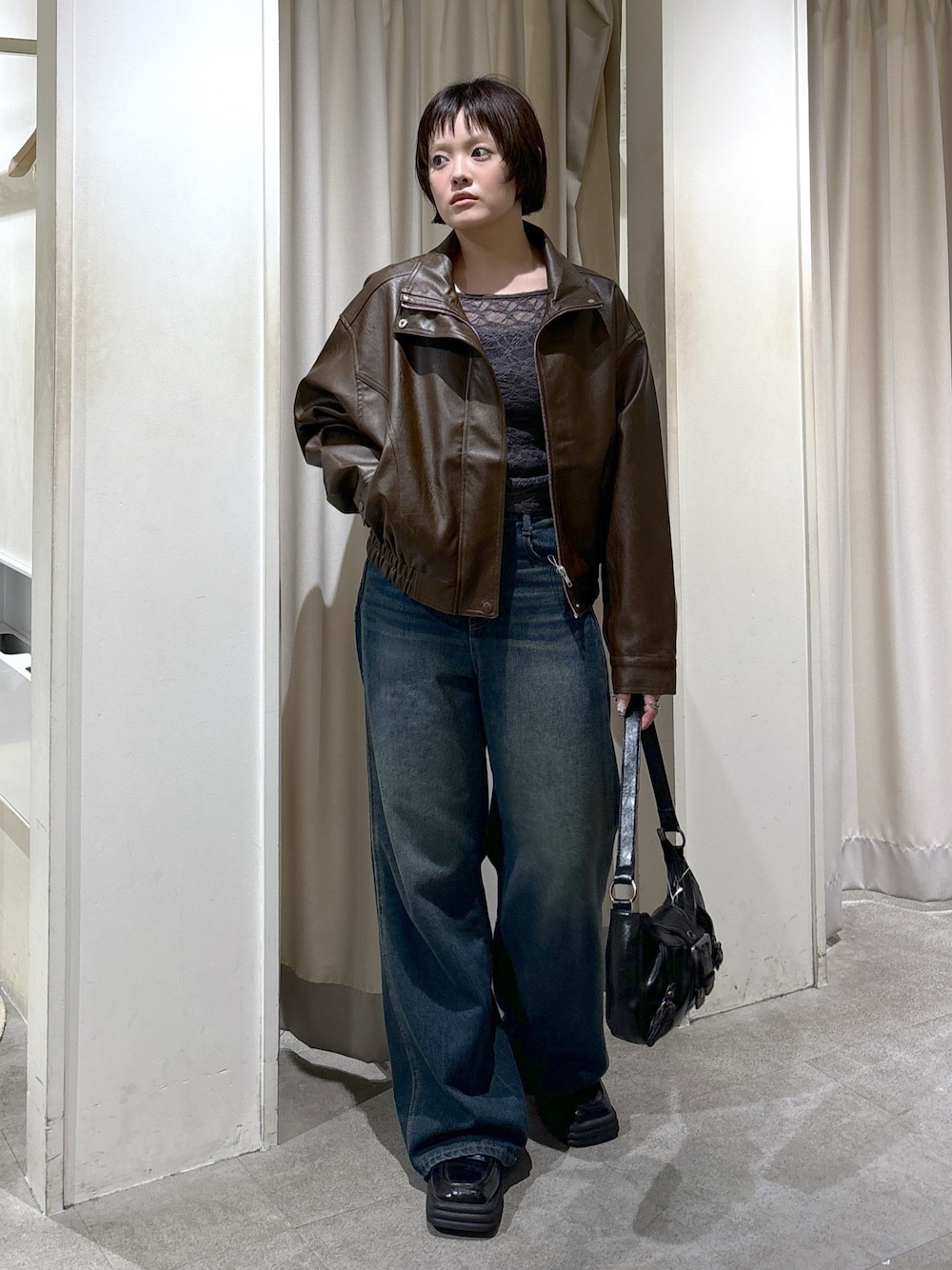 ブラウン系のブルゾン、グレー系のTシャツ/カットソー、ブルー系のデニムパンツを着用したレディースの秋コーディネートの1枚目の写真