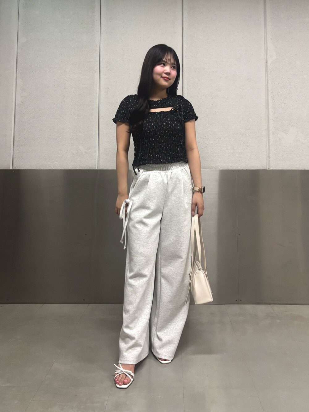 ブラック系のTシャツ/カットソー、ホワイト系のサンダル、ホワイト系のボストンバッグを着用したレディースの春コーディネートの1枚目の写真