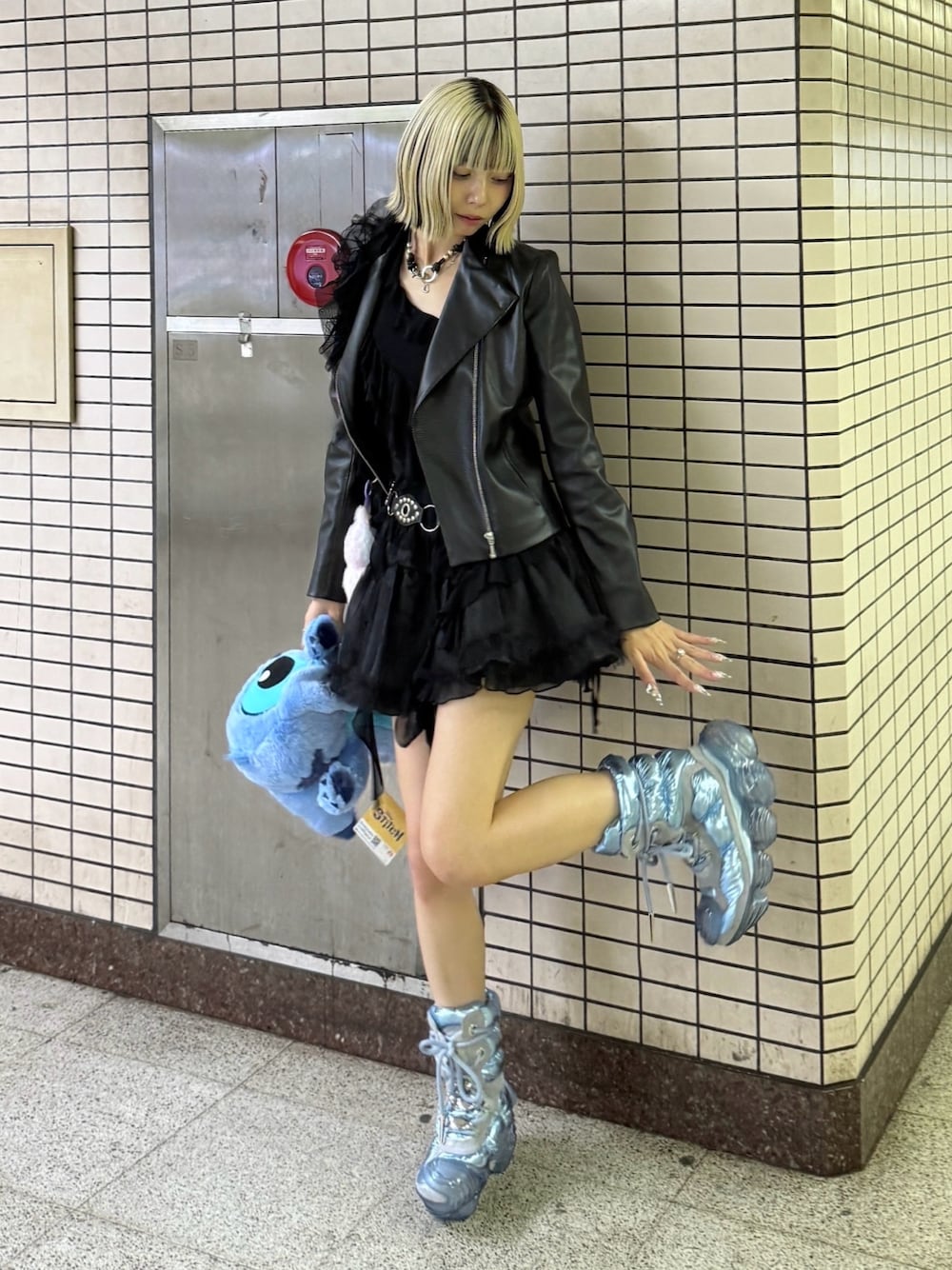 ブラック系のライダースジャケット、ブルー系のシューズ、ブラック系のスカートを着用したレディースの秋コーディネートの1枚目の写真