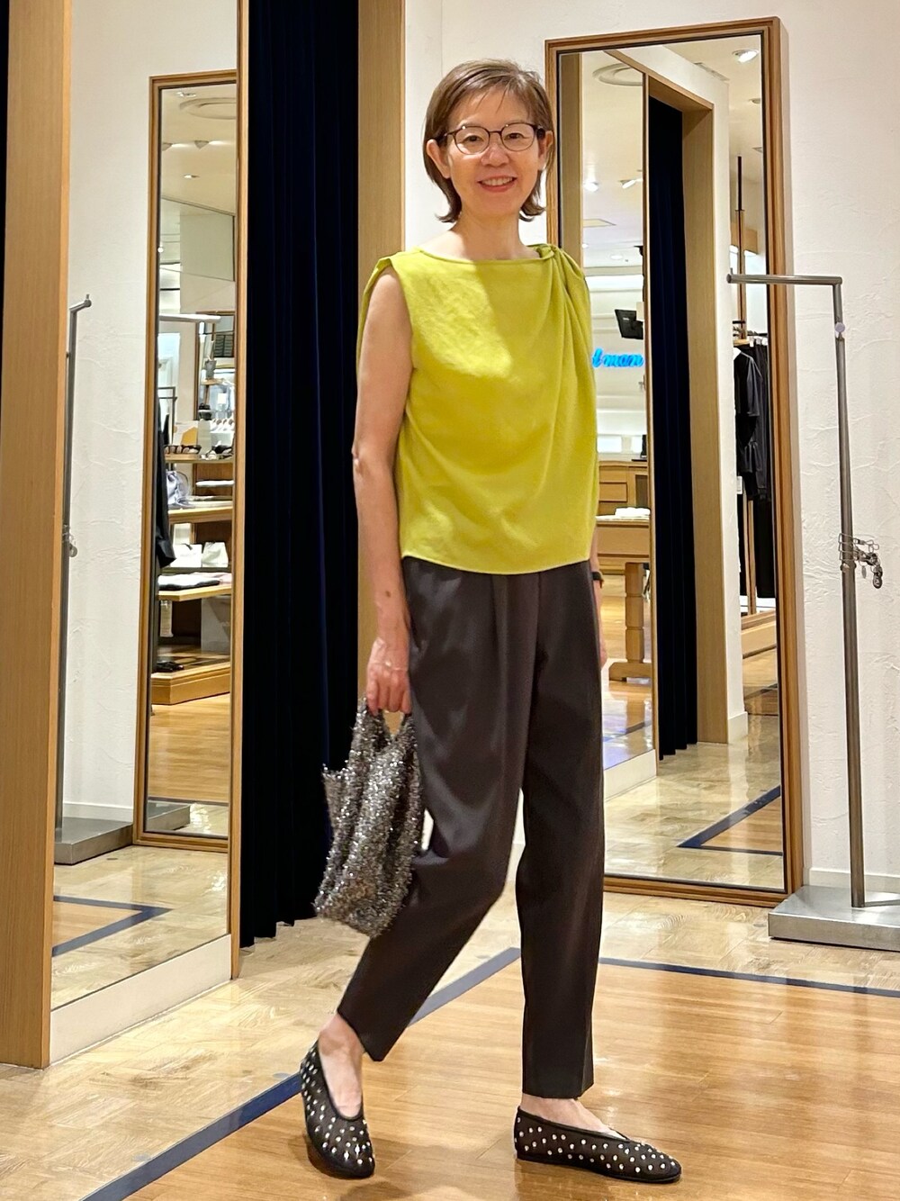 グレー系のその他パンツ、イエロー系のシャツ/ブラウス、ブラック系のバックパック/リュックを着用したレディースの夏コーディネートの1枚目の写真