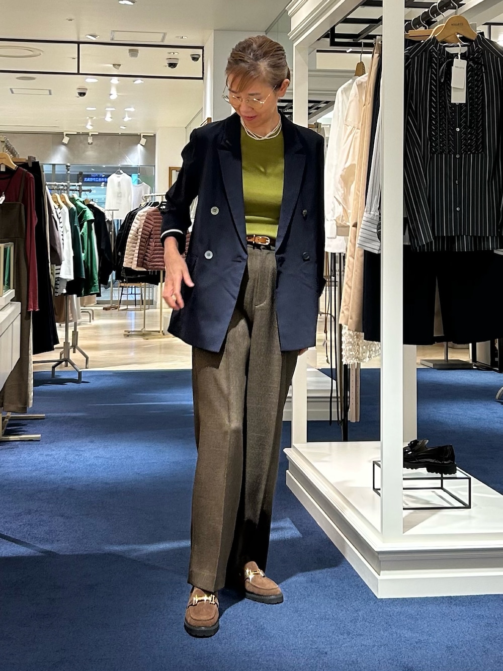 ブラウン系のその他パンツ、ブルー系のテーラードジャケット、グリーン系のニット/セーターを着用したレディースの秋コーディネートの1枚目の写真
