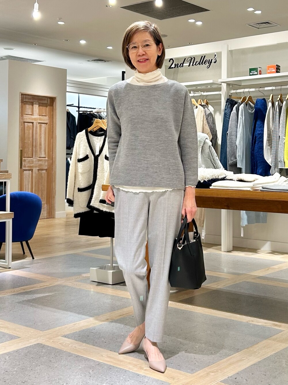 グレー系のその他パンツ、ブラック系のトートバッグ、グレー系のニット/セーターを着用したレディースの秋コーディネートの1枚目の写真