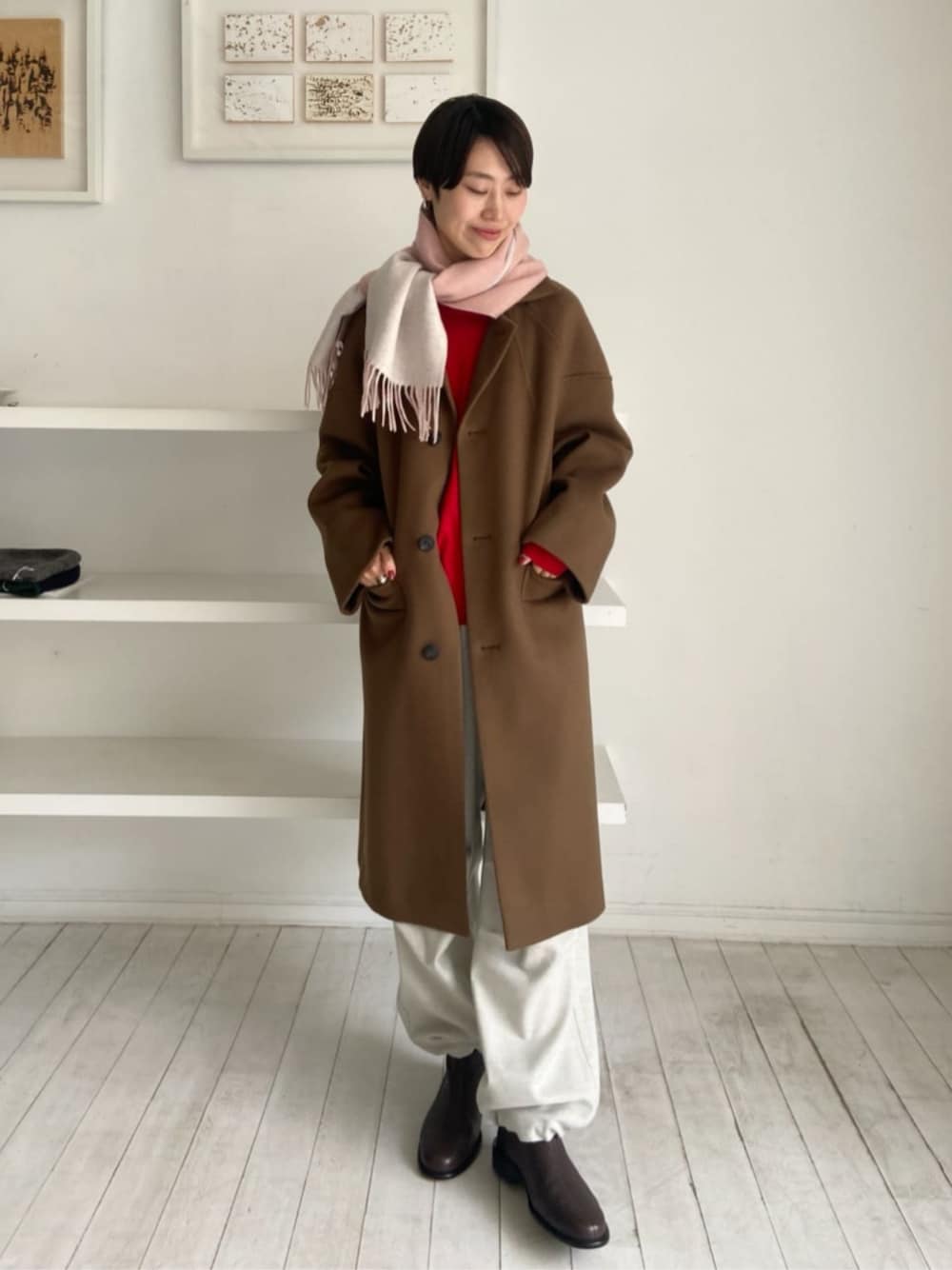 ブラウン系のブーツ、レッド系のニット/セーター、グレー系のカーゴパンツを着用したレディースの秋コーディネートの1枚目の写真