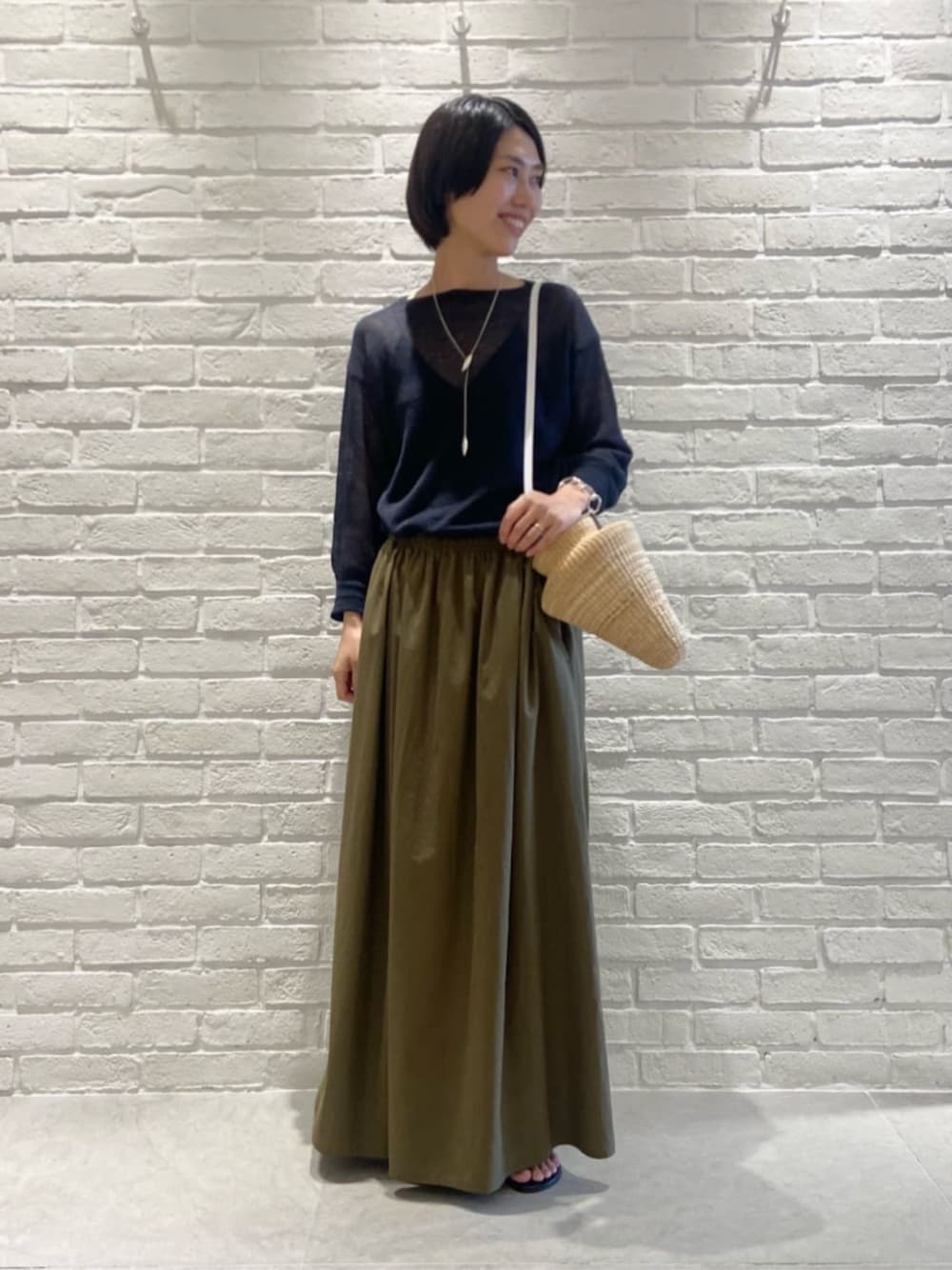 グリーン系のスカート、ブルー系のニット/セーターを着用したレディースの夏コーディネートの1枚目の写真