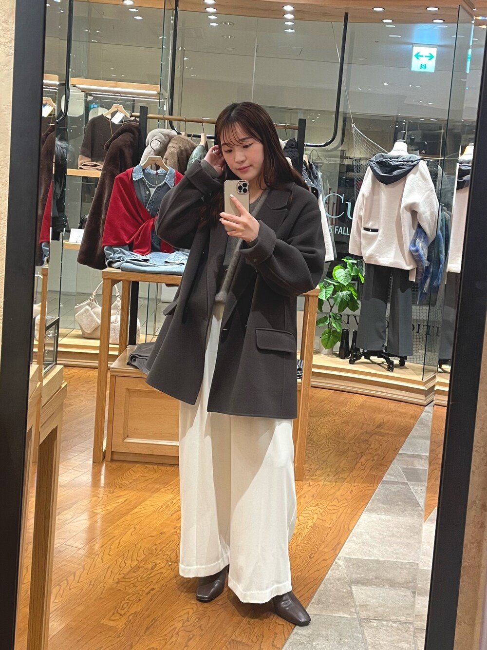 グレー系のその他アウター、ホワイト系のスラックス、ブラウン系のブーツを着用したレディースの秋コーディネートの1枚目の写真