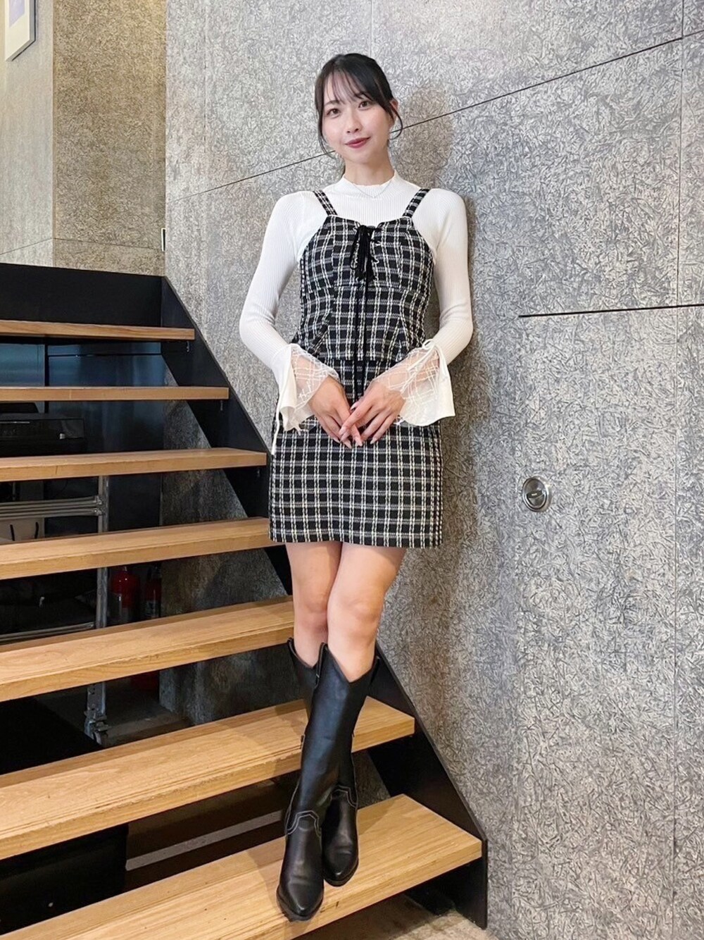 ホワイト系のニット/セーター、ブラック系のワンピースを着用したレディースの冬コーディネートの1枚目の写真