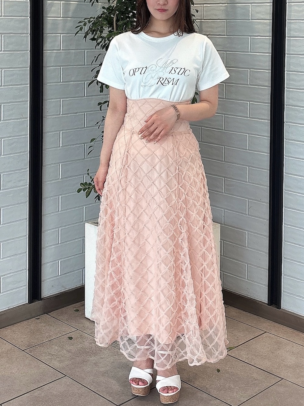 ホワイト系のTシャツ/カットソー、ホワイト系のサンダル、ピンク系のスカートを着用したレディースの春コーディネートの1枚目の写真