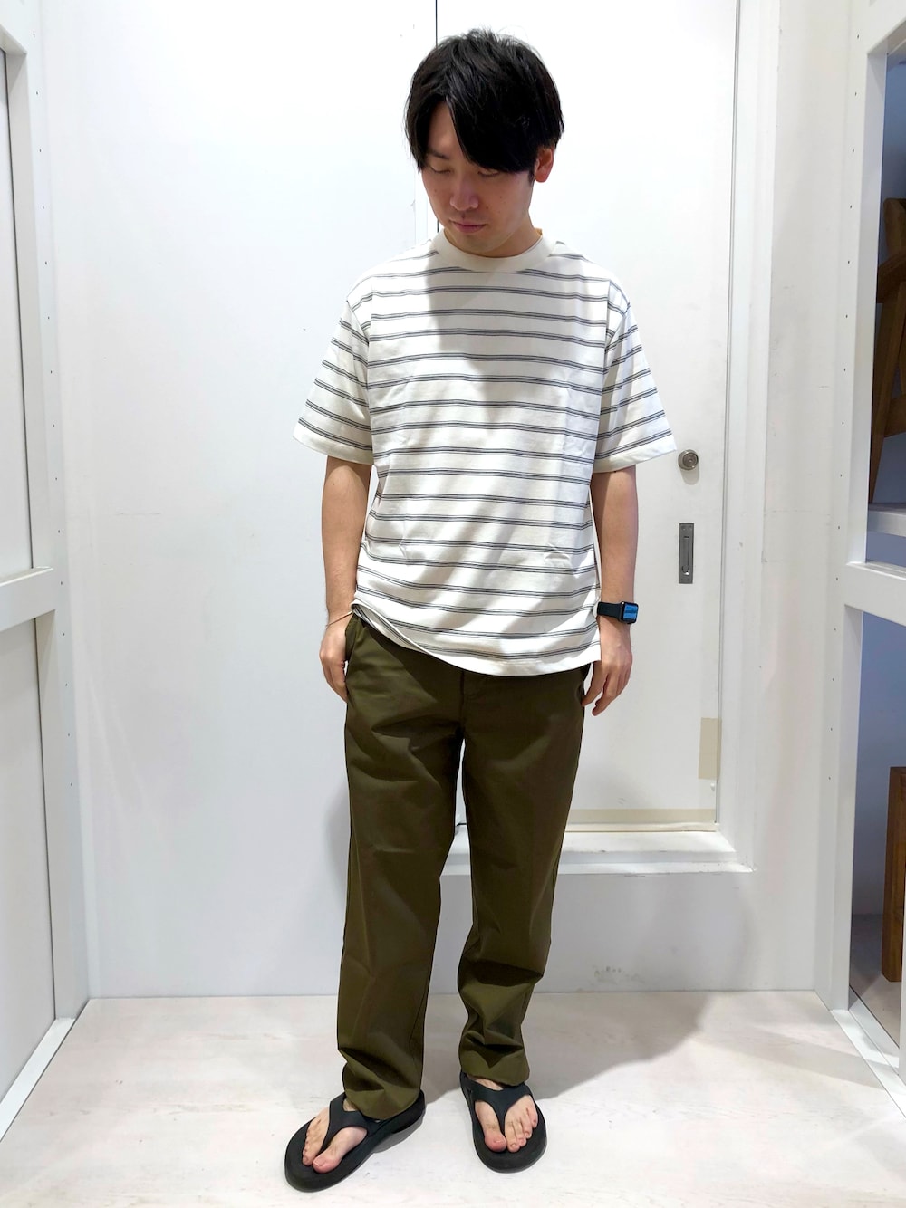ホワイト系のTシャツ/カットソー、グリーン系のチノパンツを着用したメンズの夏コーディネートの1枚目の写真