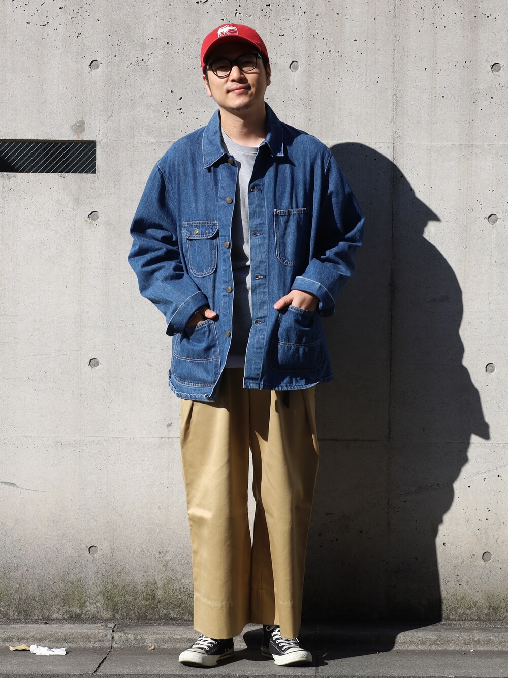 グレー系のスウェット、ベージュ系のチノパンツ、ブルー系のカバーオールを着用したメンズの冬コーディネートの1枚目の写真