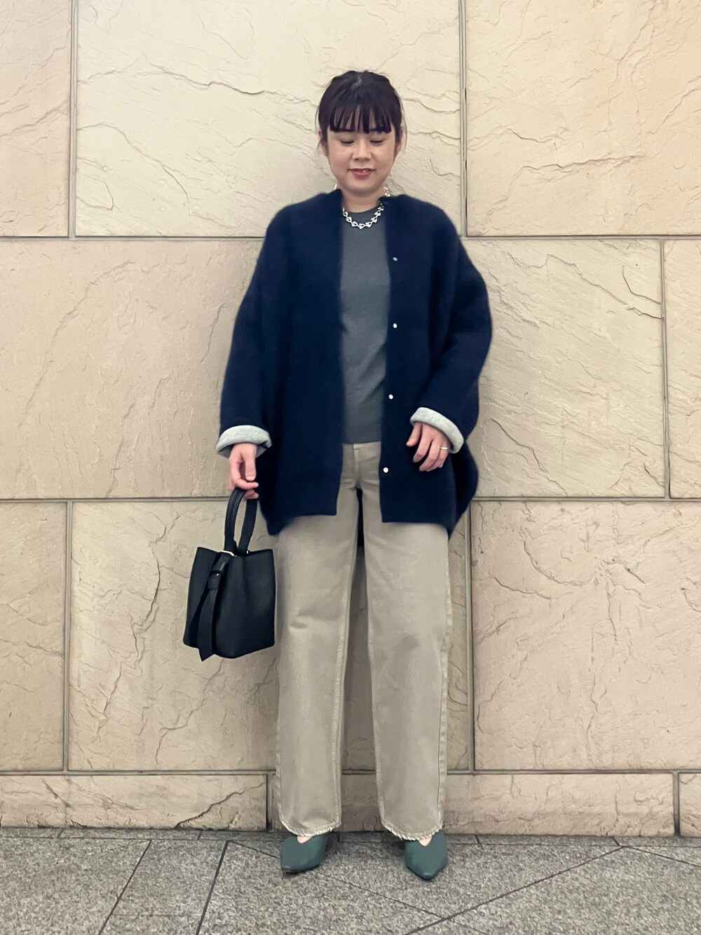 グレー系のTシャツ/カットソー、ベージュ系のデニムパンツ、ブラック系のハンドバッグを着用したレディースの秋コーディネートの1枚目の写真