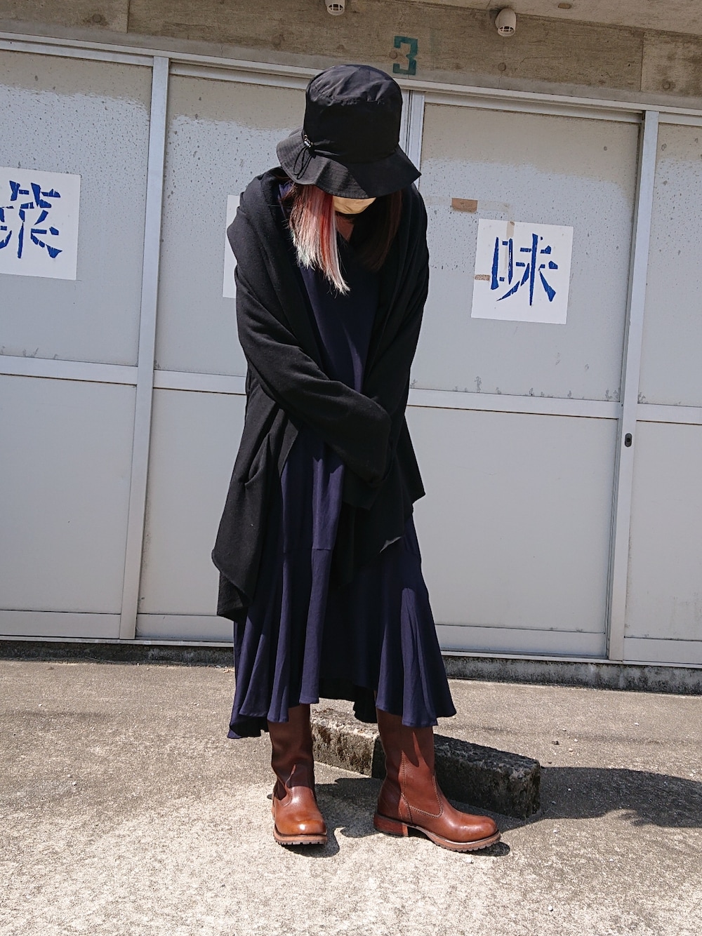 ブルー系のワンピース、ブラック系のカーディガン/ボレロ、ブラウン系のブーツを着用したレディースの春コーディネートの2枚目の写真