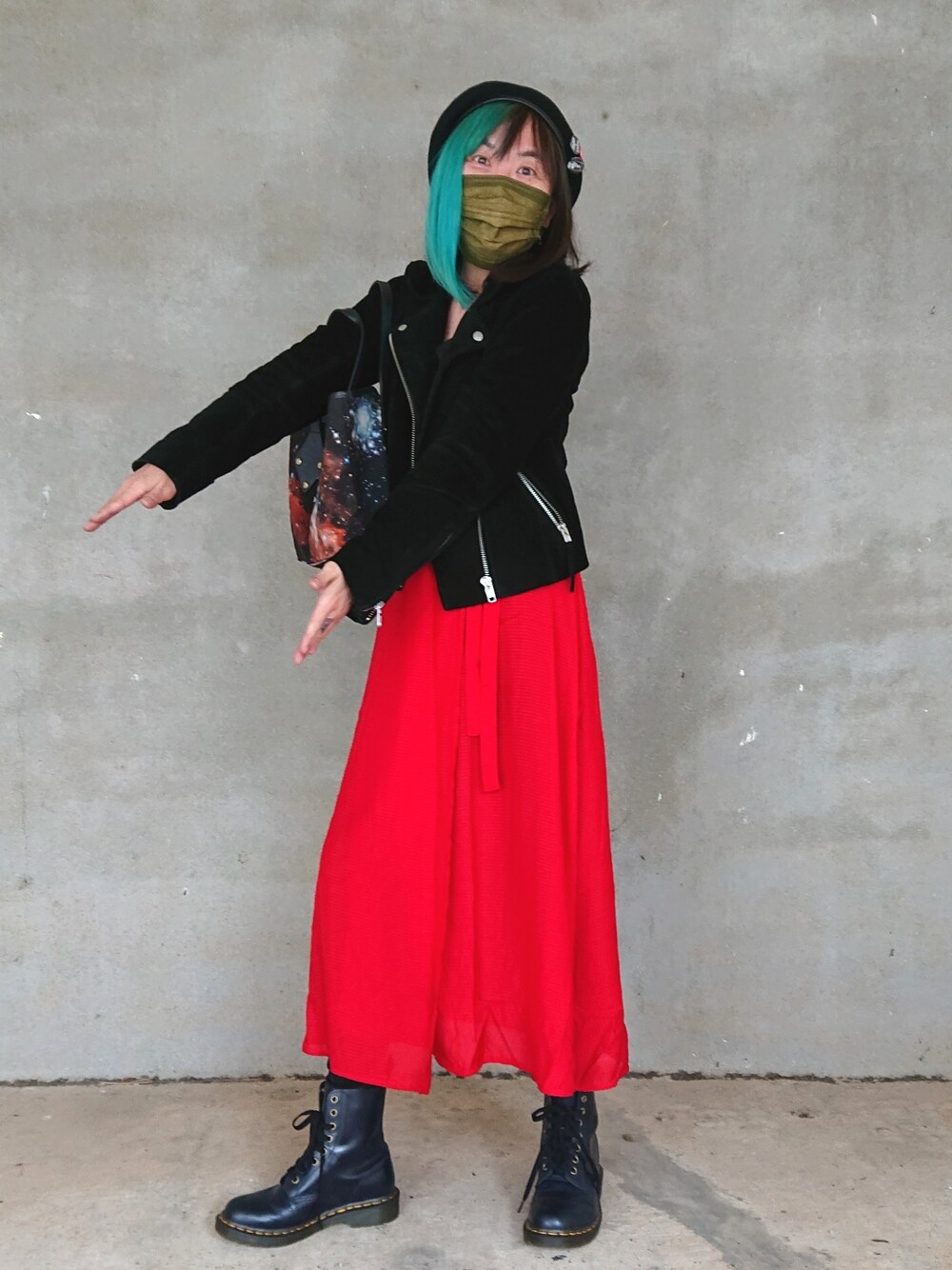 ブラック系のライダースジャケット、ブラック系のトートバッグ、ブルー系のブーツを着用したレディースの冬コーディネートの2枚目の写真