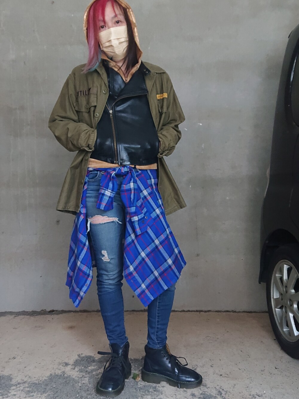 グリーン系のミリタリージャケット、ブルー系のシャツ/ブラウス、ブルー系のデニムパンツを着用したレディースの春コーディネートの2枚目の写真