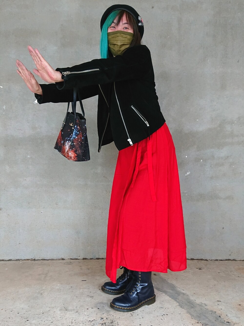 ブラック系のライダースジャケット、ブラック系のトートバッグ、ブルー系のブーツを着用したレディースの冬コーディネートの3枚目の写真