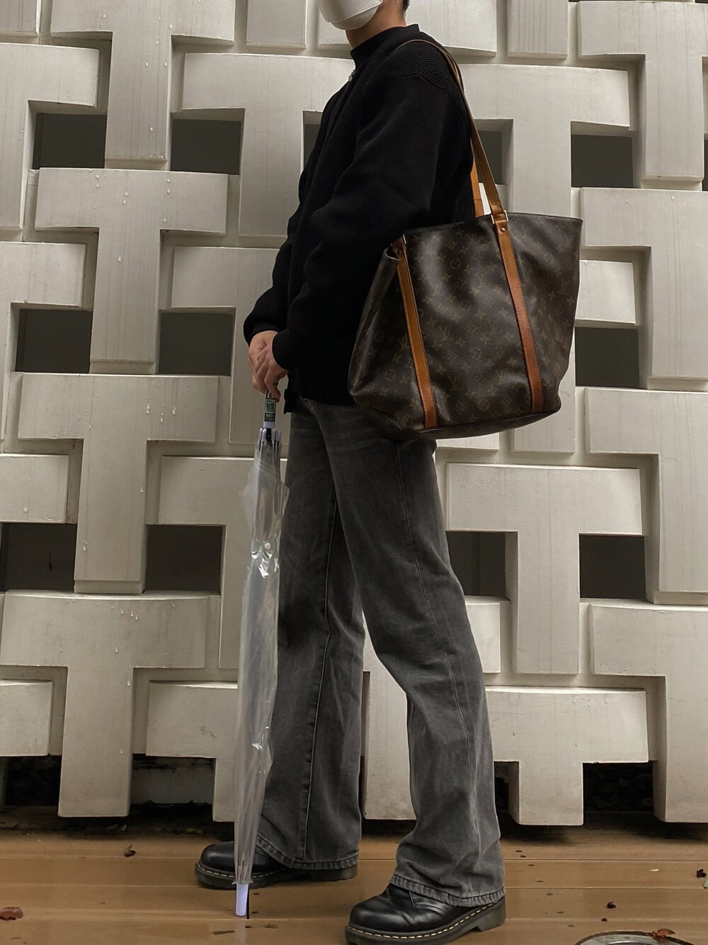 グレー系のデニムパンツ、ブラック系のブーツ、ブラウン系のトートバッグを着用したメンズの秋コーディネートの1枚目の写真