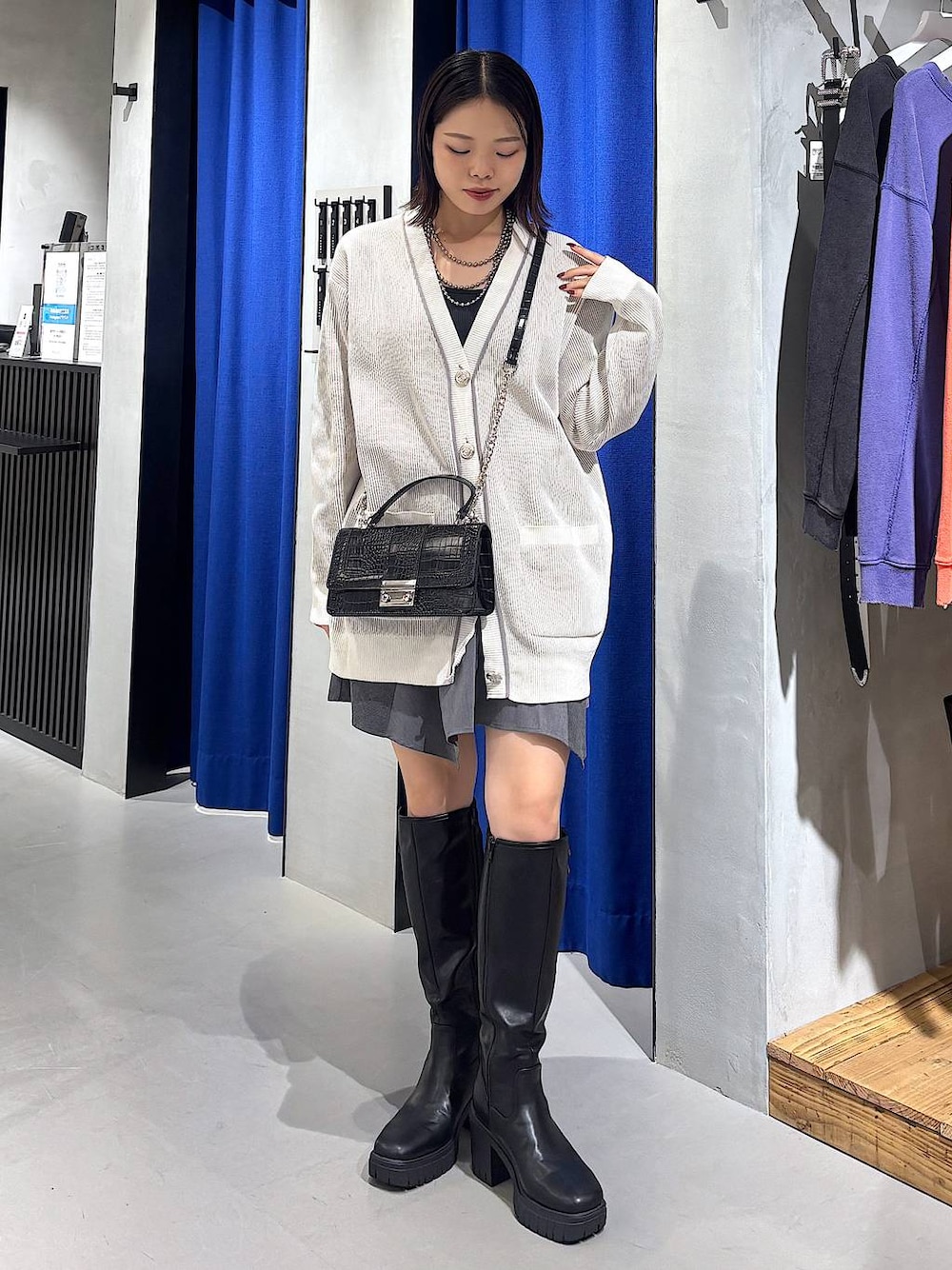 ブラック系のキャミソール、グレー系のスカート、ブラック系のハンドバッグを着用したレディースの秋コーディネートの1枚目の写真