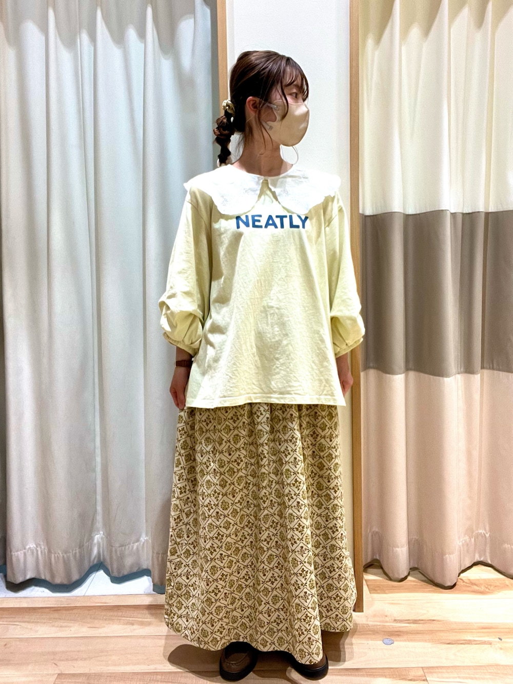 イエロー系のTシャツ/カットソー、ベージュ系のスカート、ホワイト系のストール/ショールを着用したレディースの春コーディネートの1枚目の写真