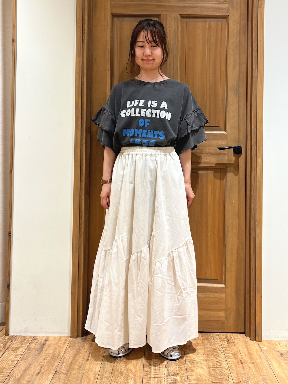シルバー系のサンダル、ホワイト系のスカート、グレー系のTシャツ/カットソーを着用したレディースの夏コーディネートの1枚目の写真