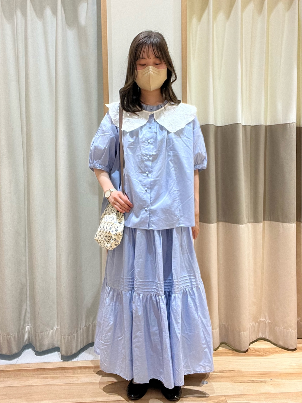 ブルー系のシャツ/ブラウス、ブルー系のスカート、ホワイト系のハンドバッグを着用したレディースの春コーディネートの1枚目の写真
