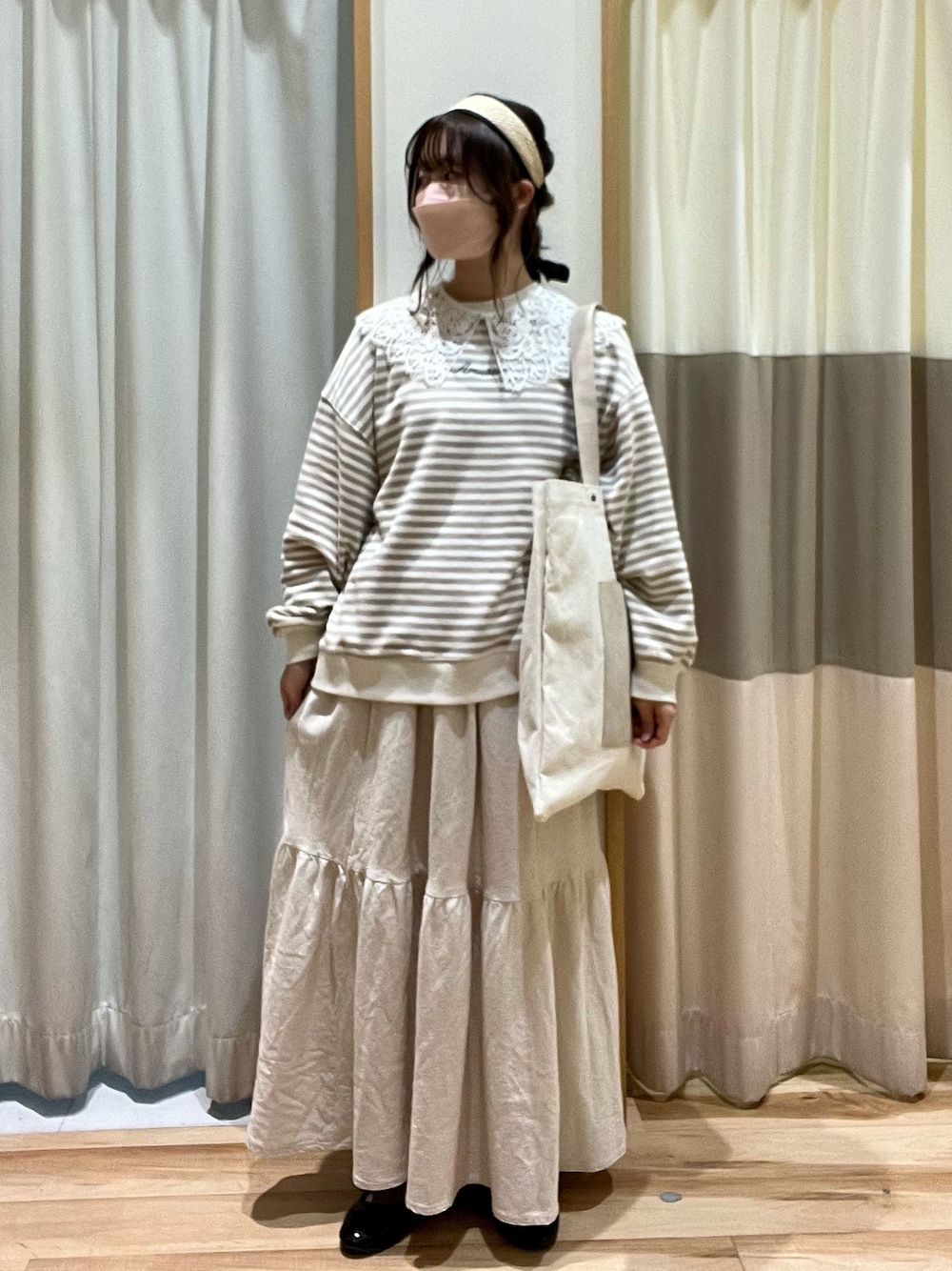 ホワイト系のニット/セーター、ベージュ系のハンドバッグ、ホワイト系のスカートを着用したレディースの冬コーディネートの1枚目の写真