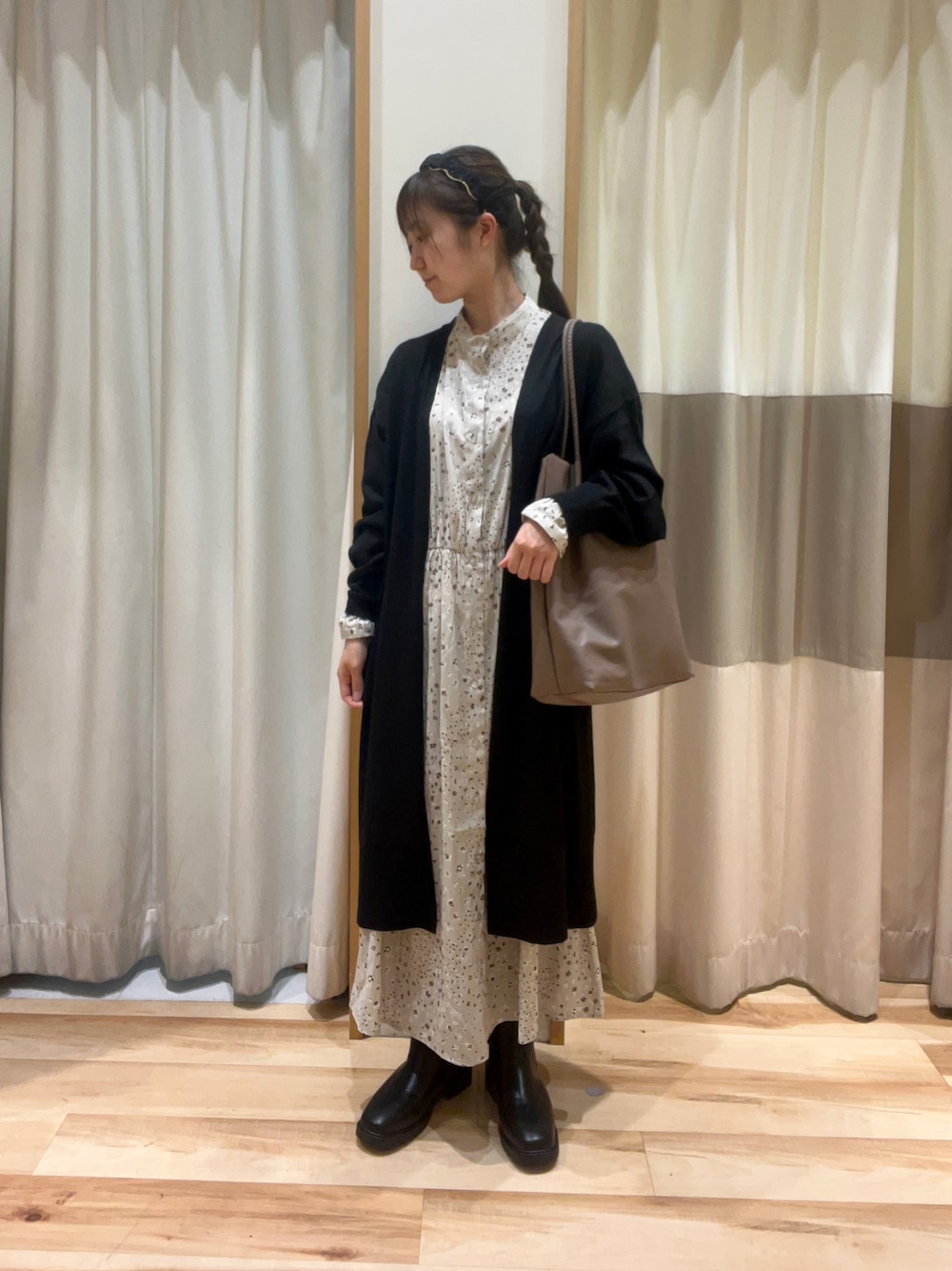 ベージュ系のワンピース、ベージュ系のハンドバッグ、ブラック系のドレスシューズを着用したレディースの秋コーディネートの1枚目の写真