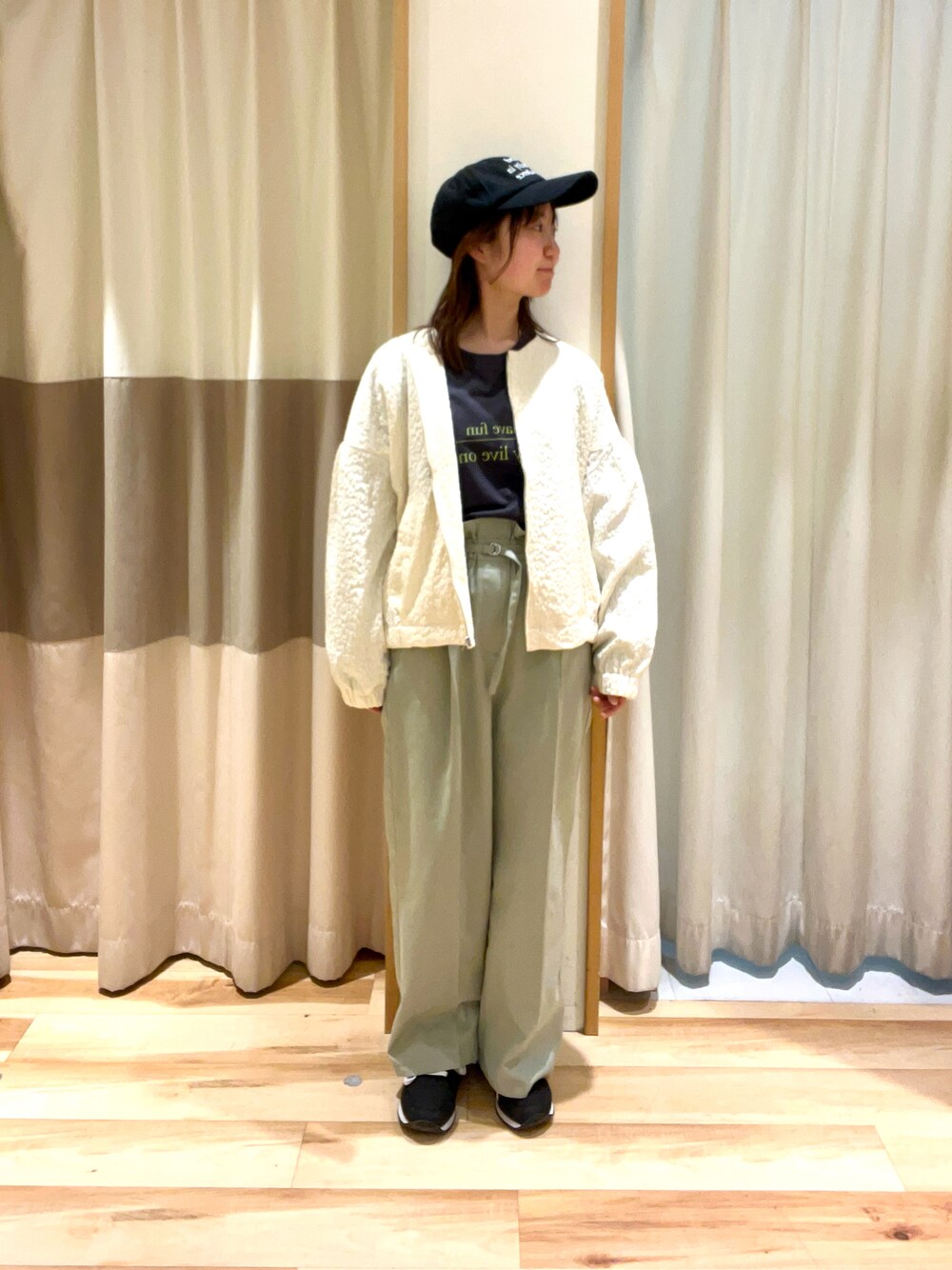 グレー系のTシャツ/カットソー、ホワイト系のブルゾン、グリーン系のその他パンツを着用したレディースの春コーディネートの1枚目の写真