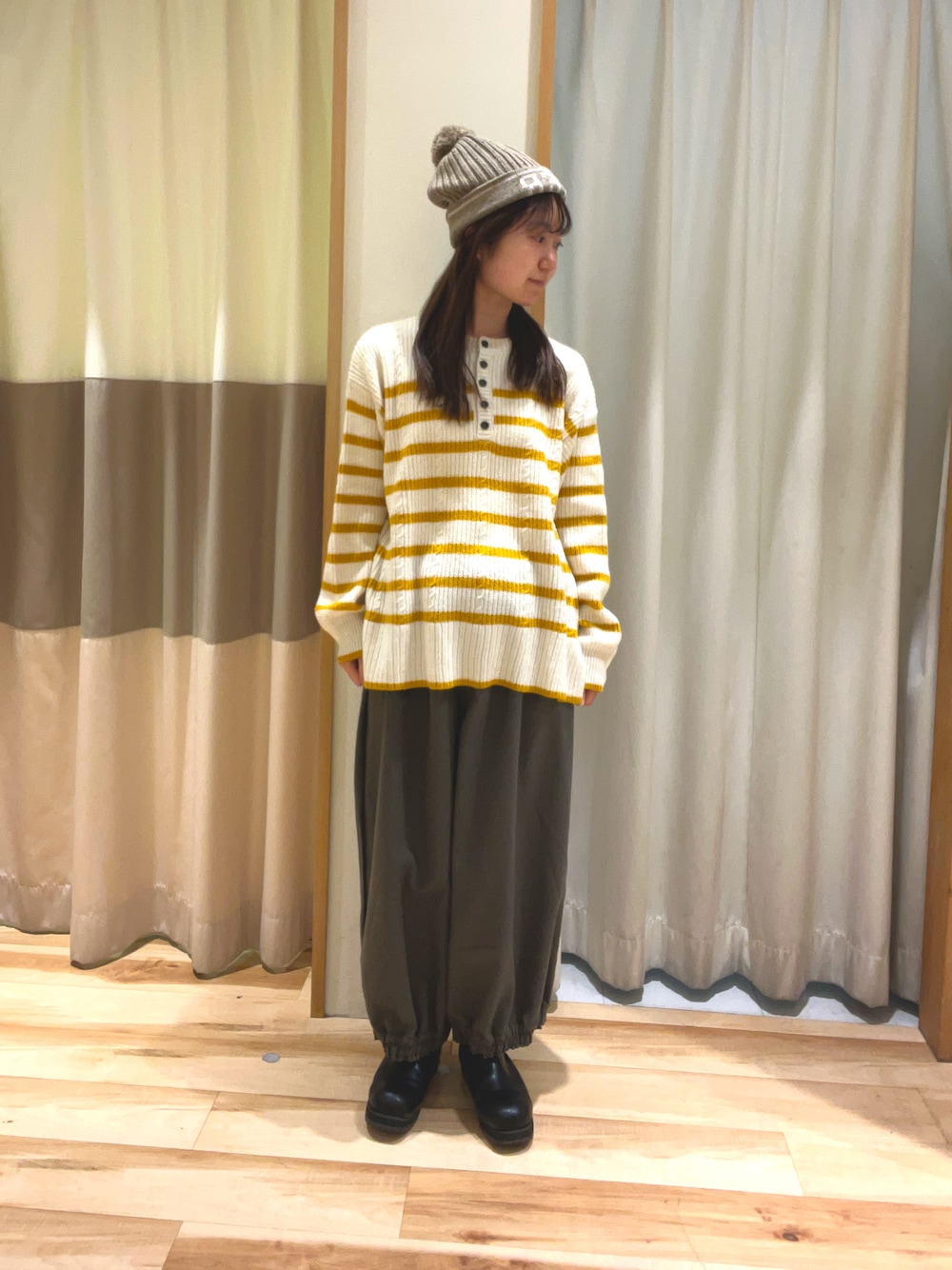 ブラウン系のその他パンツ、イエロー系のカーディガン/ボレロ、ブラウン系のニットキャップ/ビーニーを着用したレディースの冬コーディネートの1枚目の写真