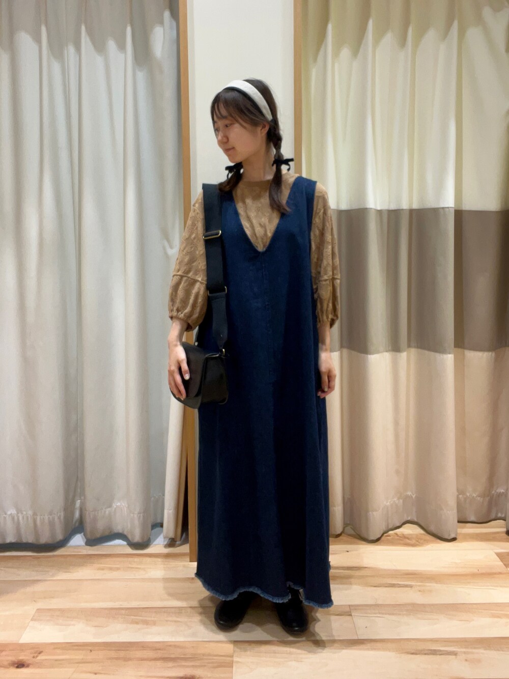 ベージュ系のTシャツ/カットソー、ブルー系のワンピース、ブラック系のハンドバッグを着用したレディースの秋コーディネートの1枚目の写真