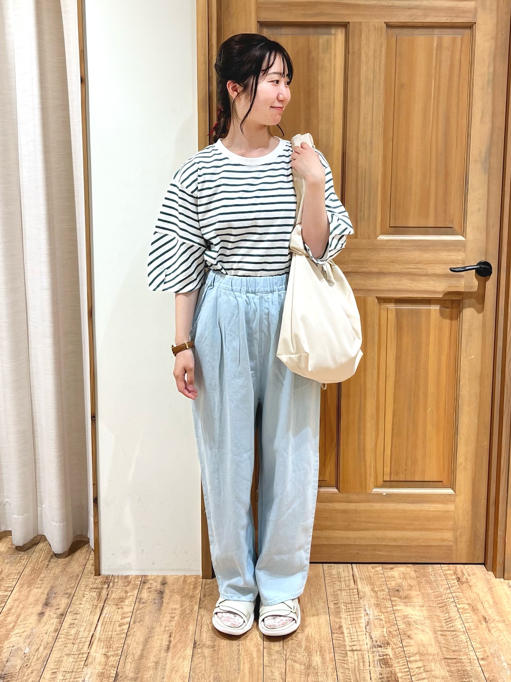 ブルー系のその他パンツ、ベージュ系のサンダル、ホワイト系のハンドバッグを着用したレディースの夏コーディネートの1枚目の写真