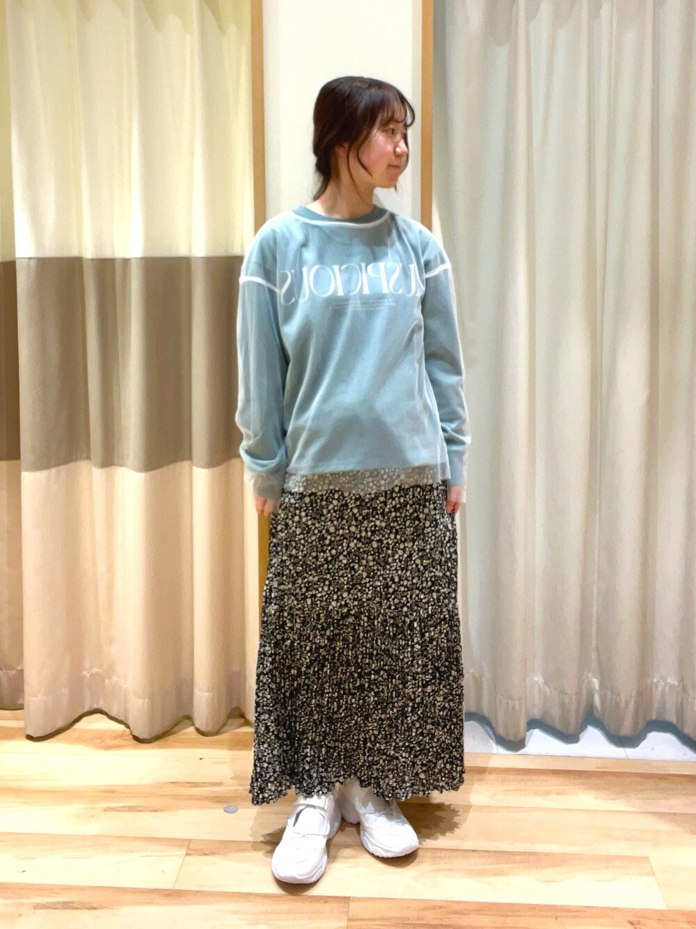 ブラック系のスカート、ホワイト系のTシャツ/カットソー、グリーン系のTシャツ/カットソーを着用したレディースの春コーディネートの1枚目の写真