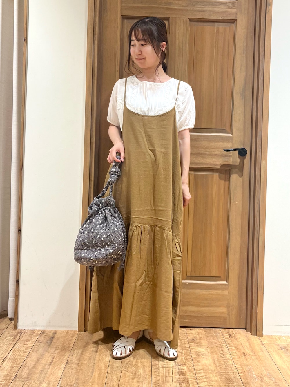 ホワイト系のサンダル、ホワイト系のTシャツ/カットソー、イエロー系のワンピースを着用したレディースの夏コーディネートの1枚目の写真