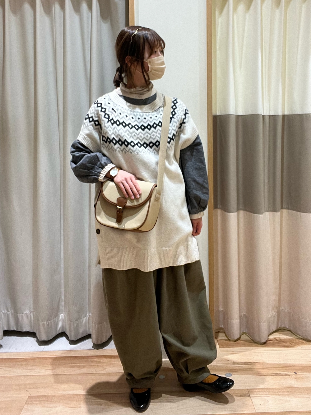 グリーン系のその他パンツ、ベージュ系のショルダーバッグ、ホワイト系のベストを着用したレディースの冬コーディネートの1枚目の写真