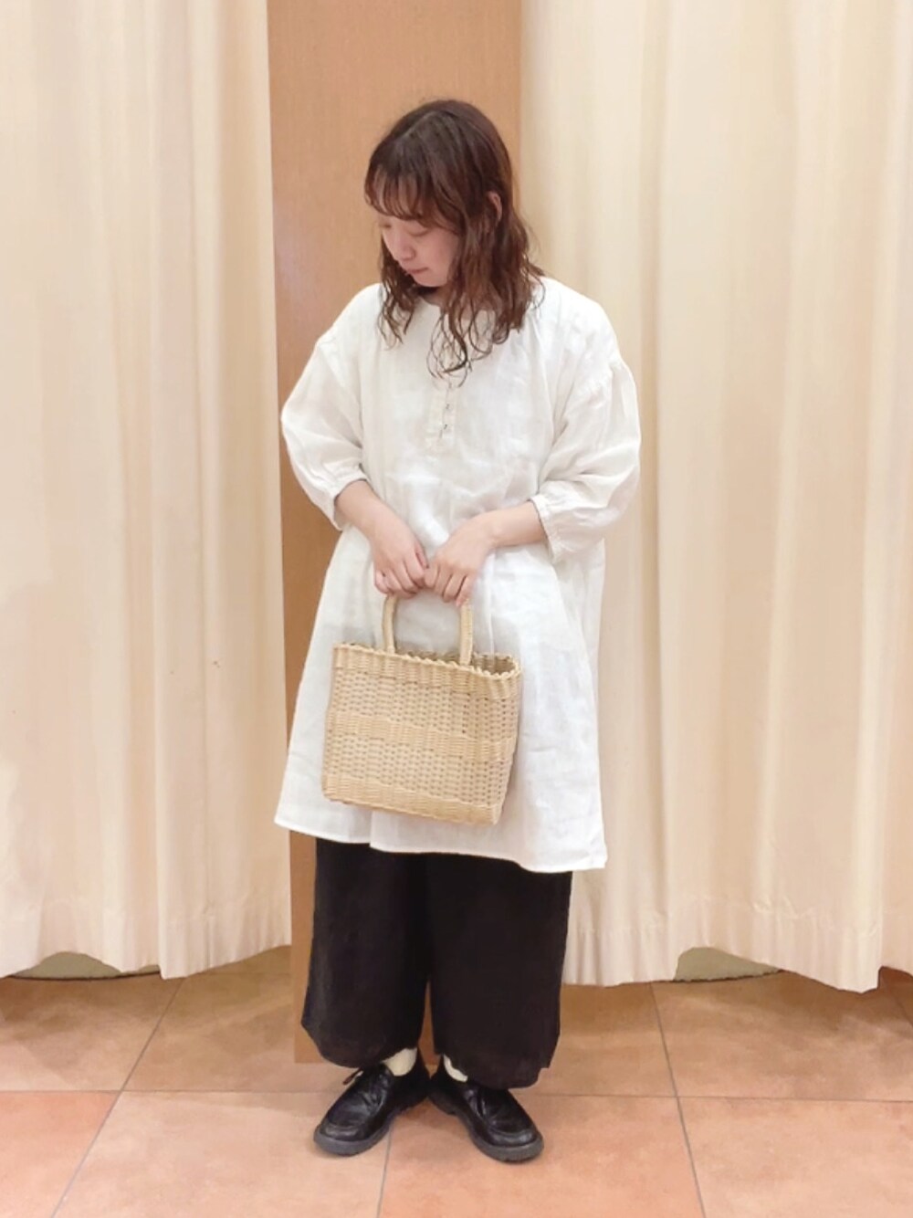 ベージュ系のトートバッグ、ブラック系のその他シューズ、ホワイト系のシャツ/ブラウスを着用したレディースの夏コーディネートの1枚目の写真