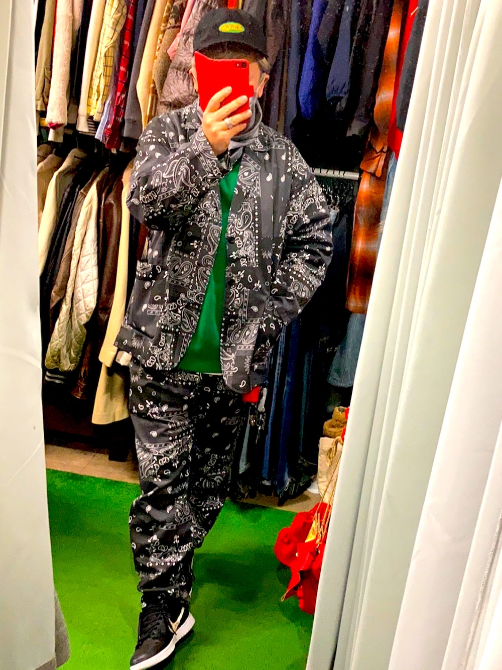 グリーン系のニット/セーター、ブラック系のセットアップ、ブラック系のスニーカーを着用したメンズの秋コーディネートの1枚目の写真