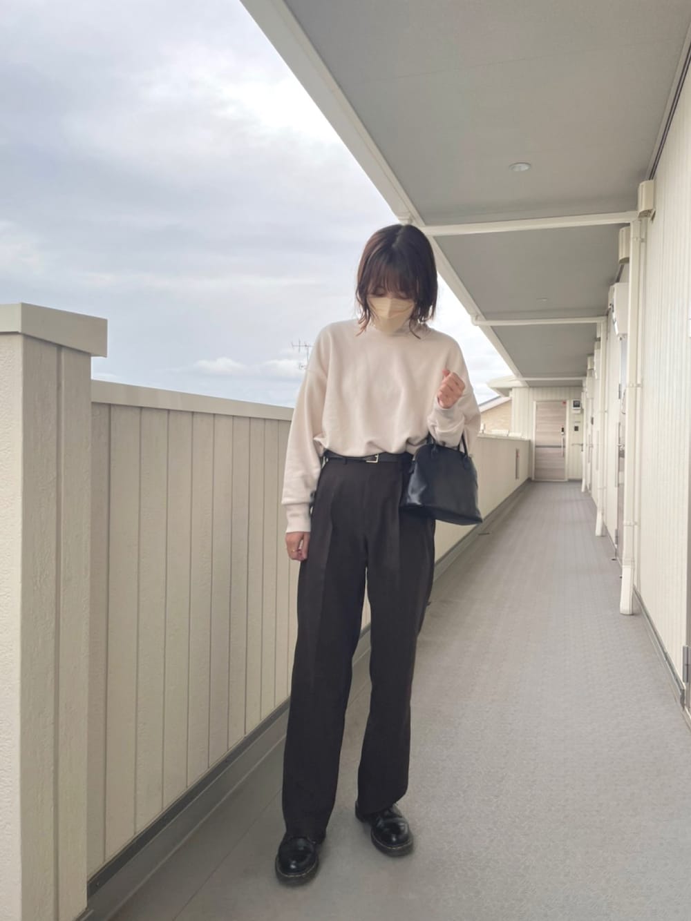 ブラウン系のその他パンツ、ブラック系のドレスシューズ、ブラック系のボストンバッグを着用したレディースの春コーディネートの1枚目の写真